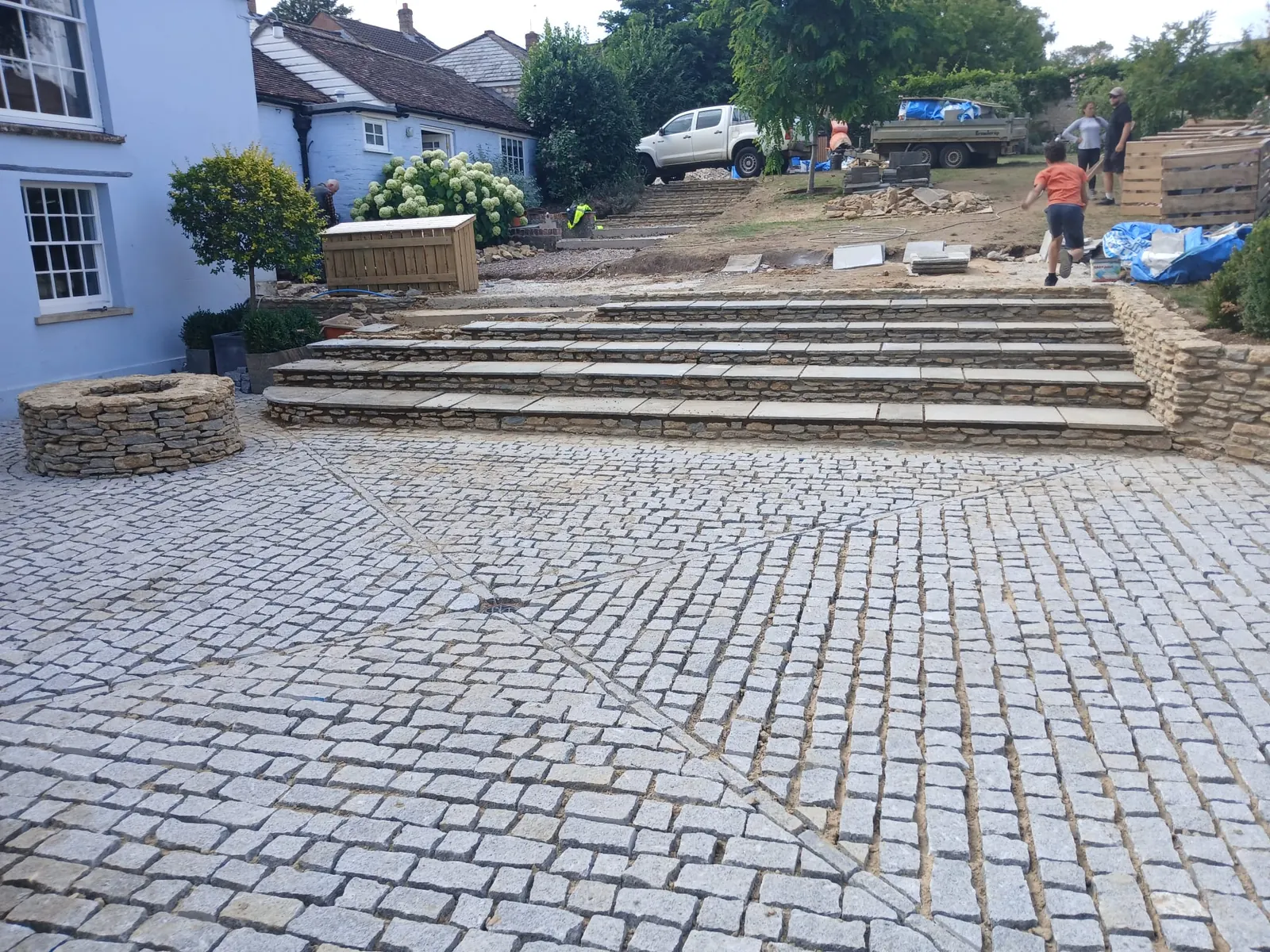 A cobbled courtyard leading to broad stone garden steps