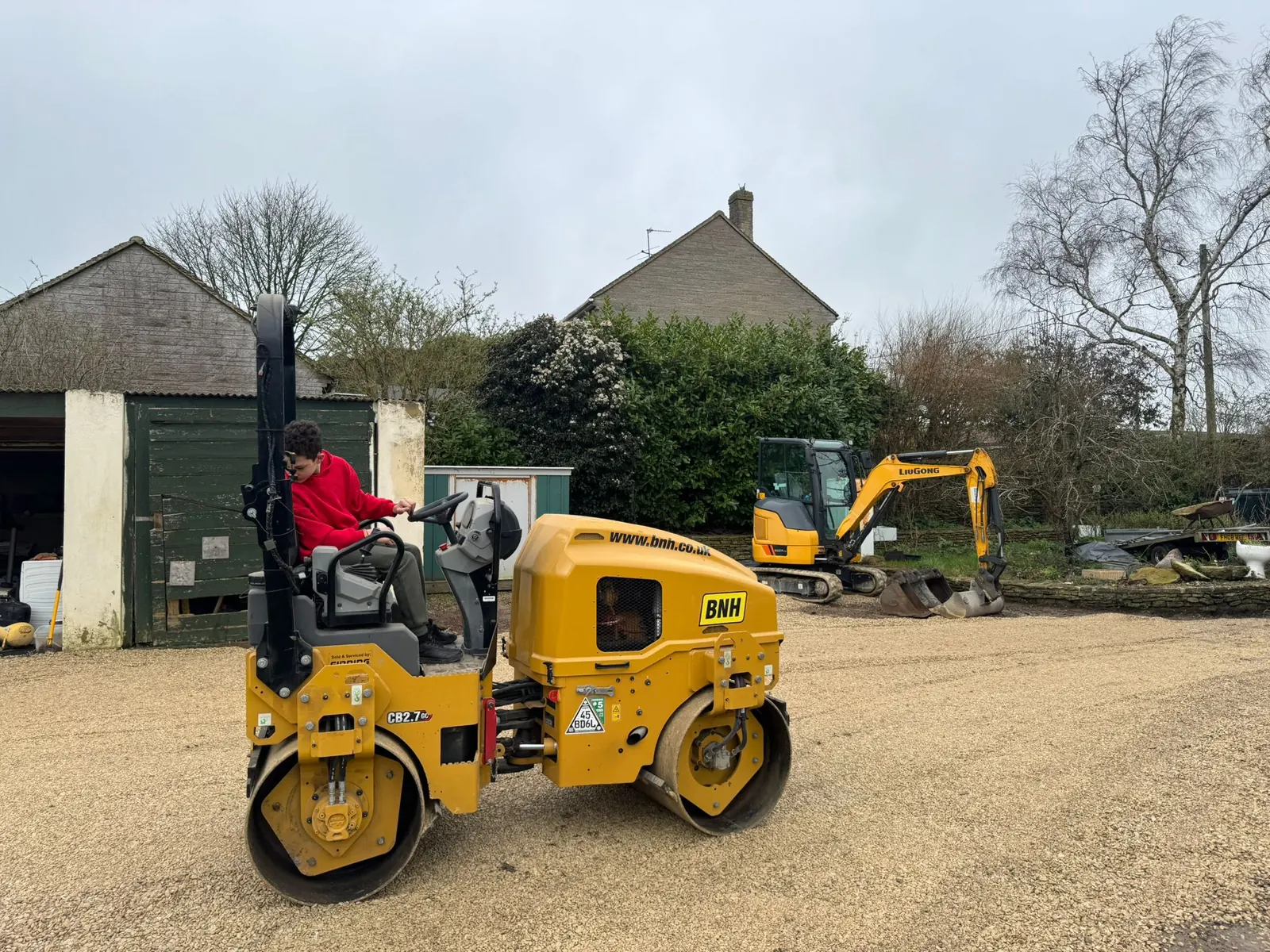 A ride-on roller compacting the base of a new drive