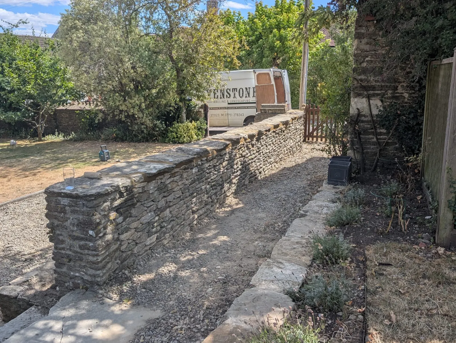 A dry stone garden wall running beside a gravel path