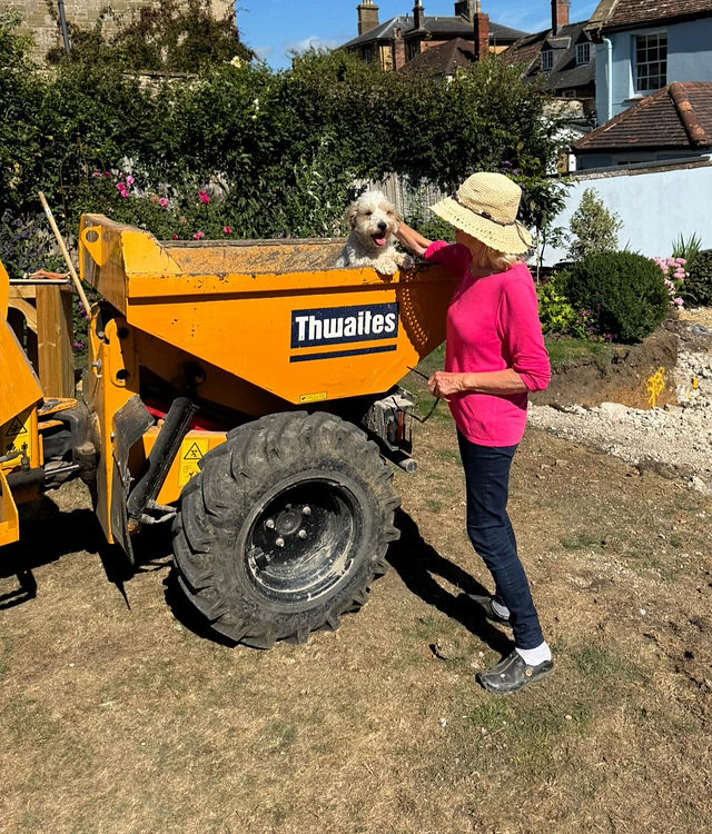 A tracked dumper on site in a garden during groundworks
