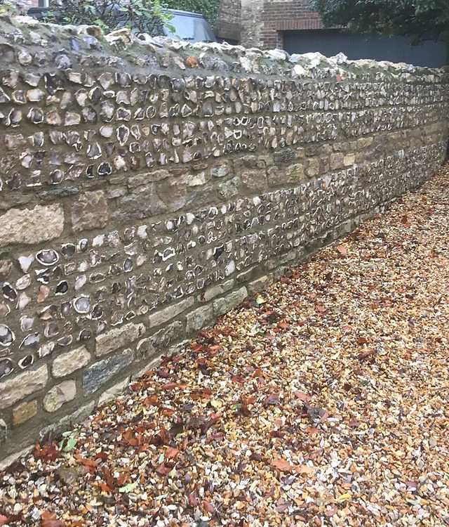 A flint wall running beside a gravel path