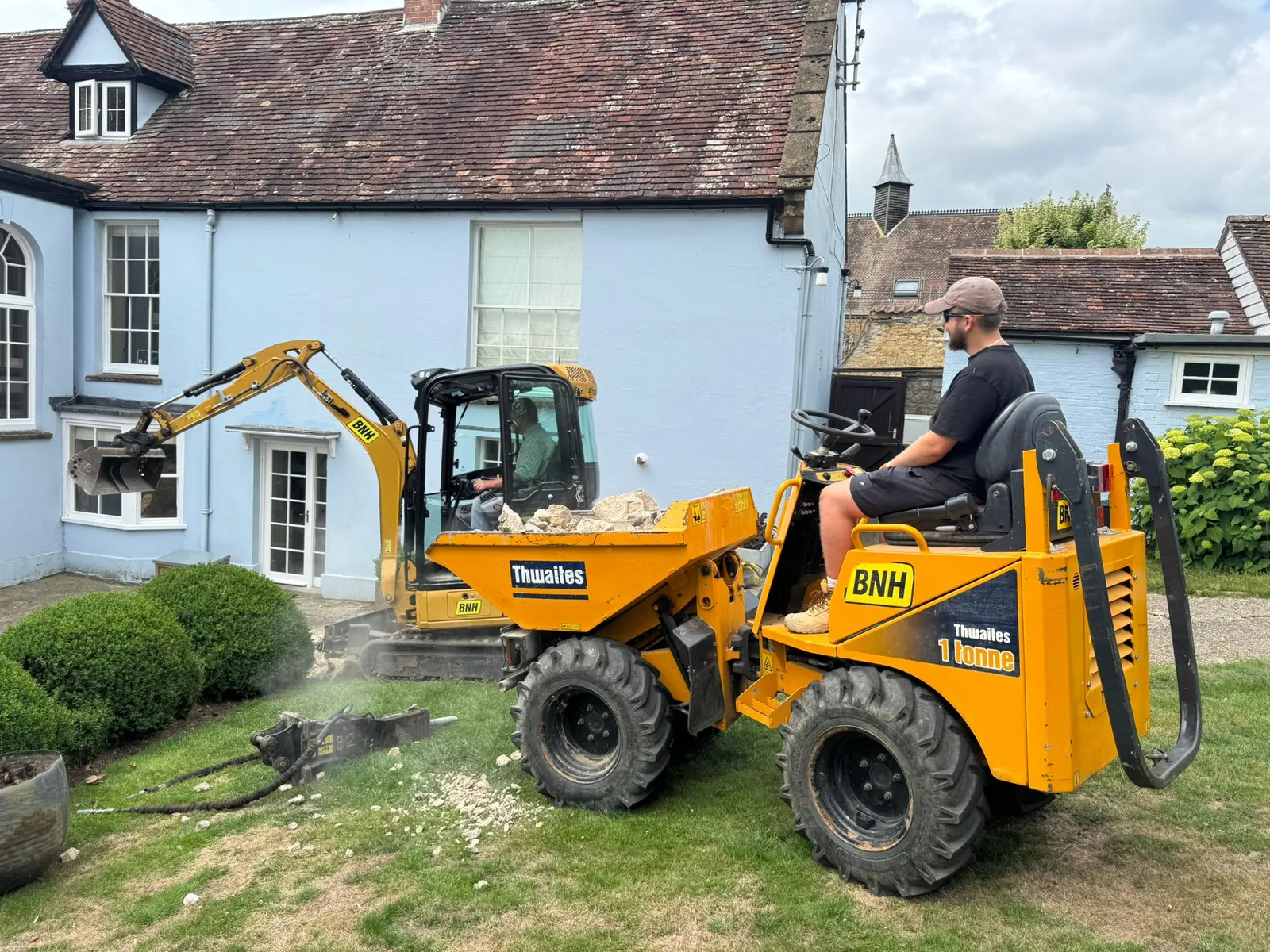 A compact loader removing material during garden groundworks