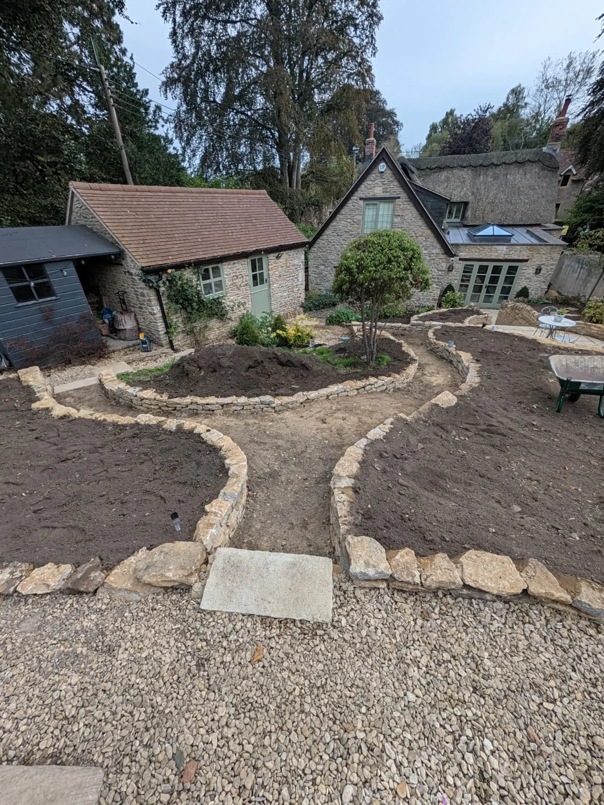 An overview of a landscaped cottage garden with flowing stone borders