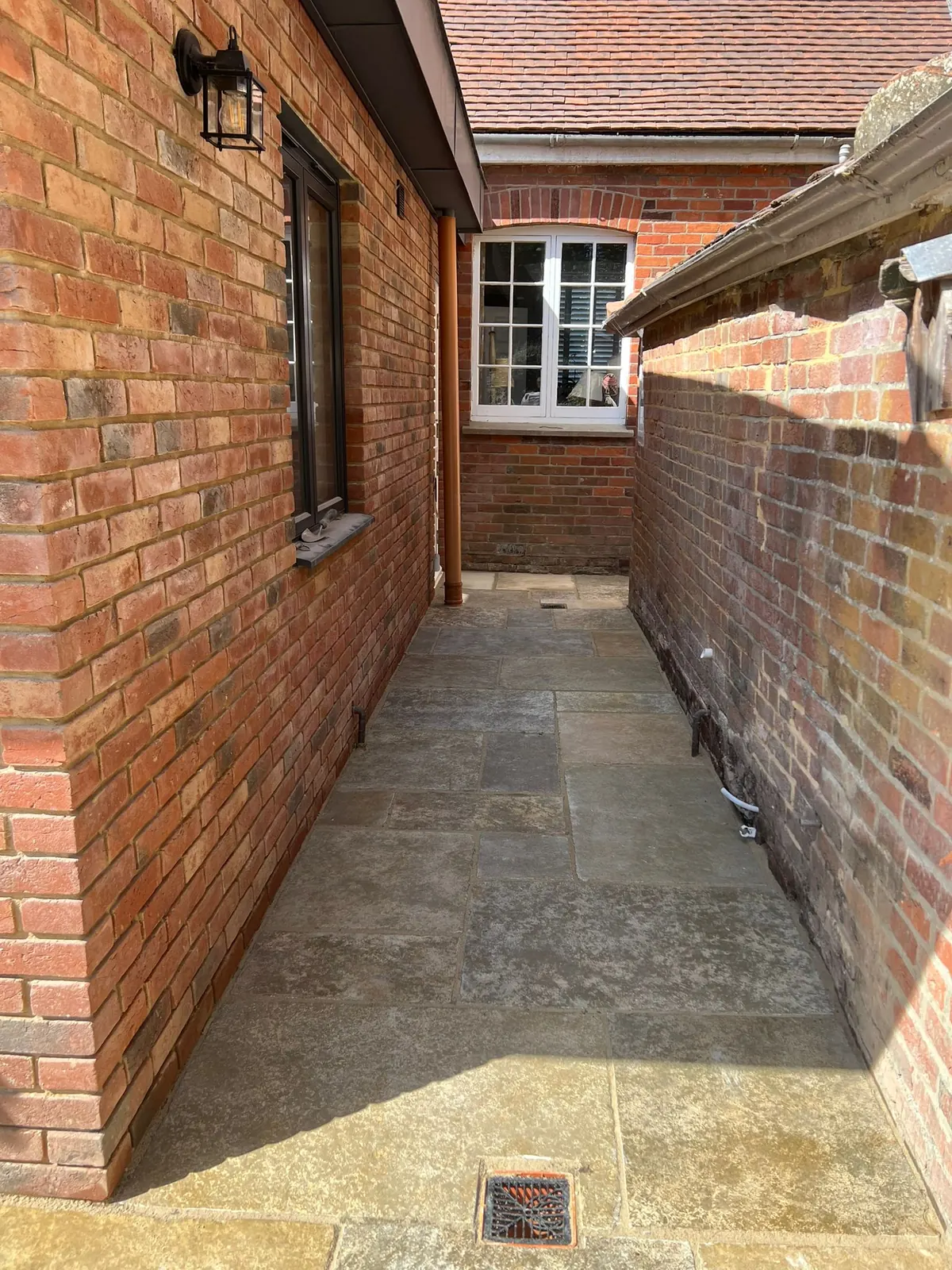 A narrow side passage newly paved in natural stone