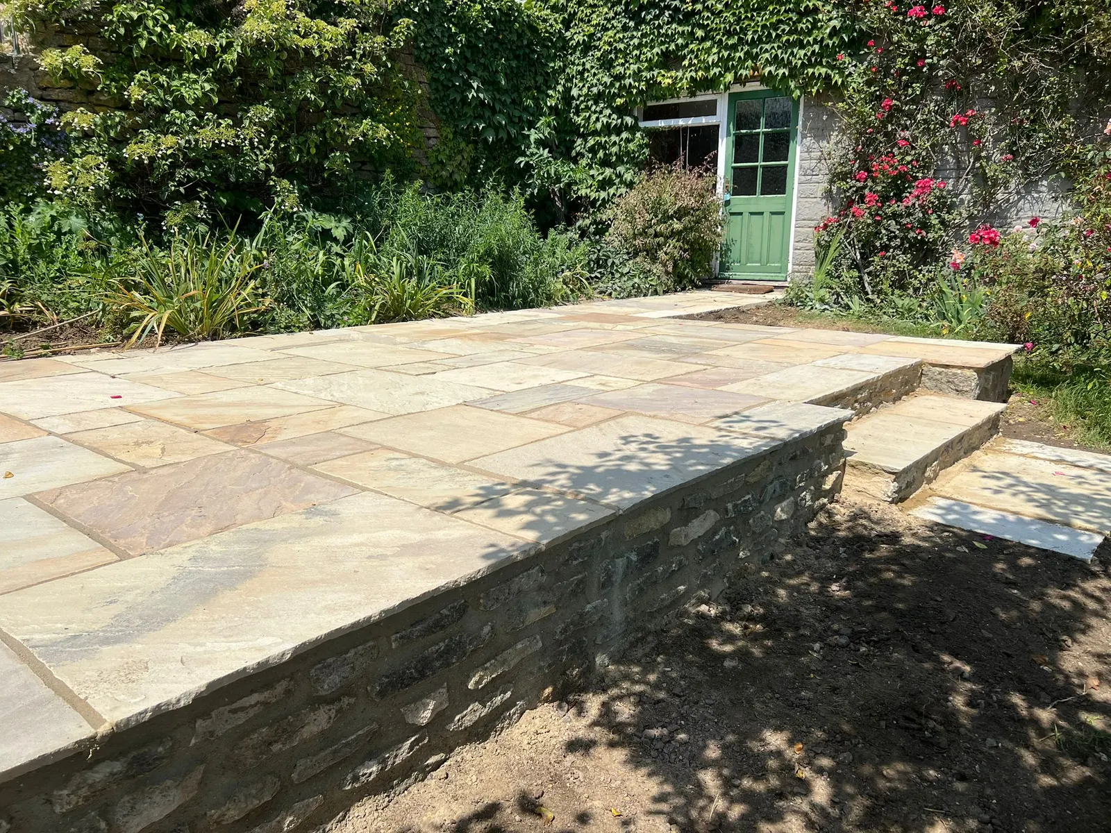 A raised sandstone terrace built above a dry stone retaining wall