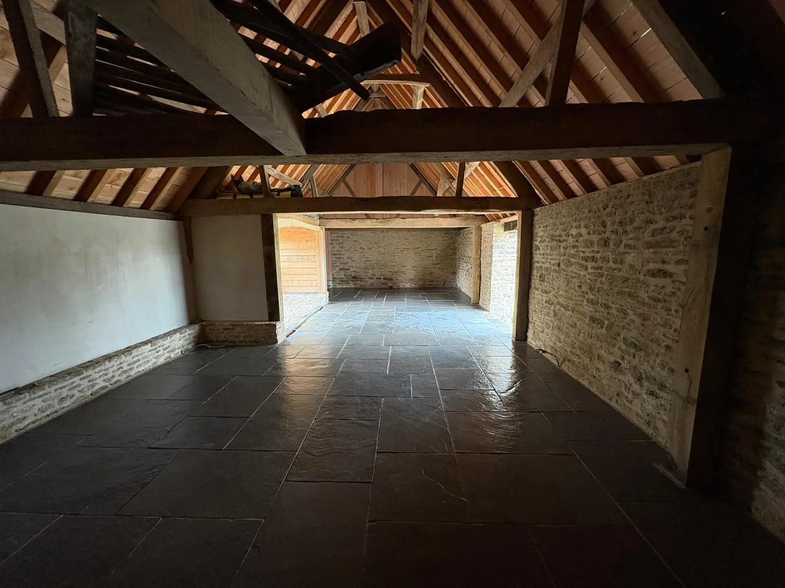 The stone interior of a restored barn with a newly laid floor
