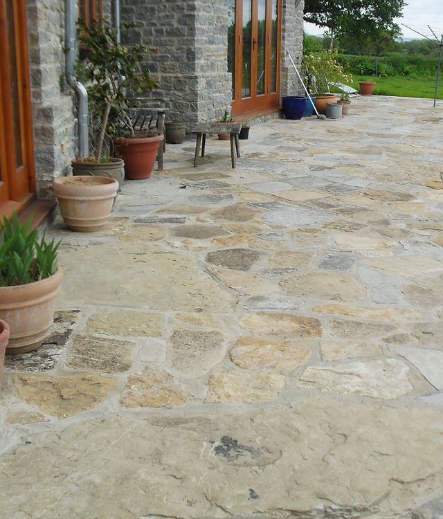 A terrace of random stone flags outside a stone house