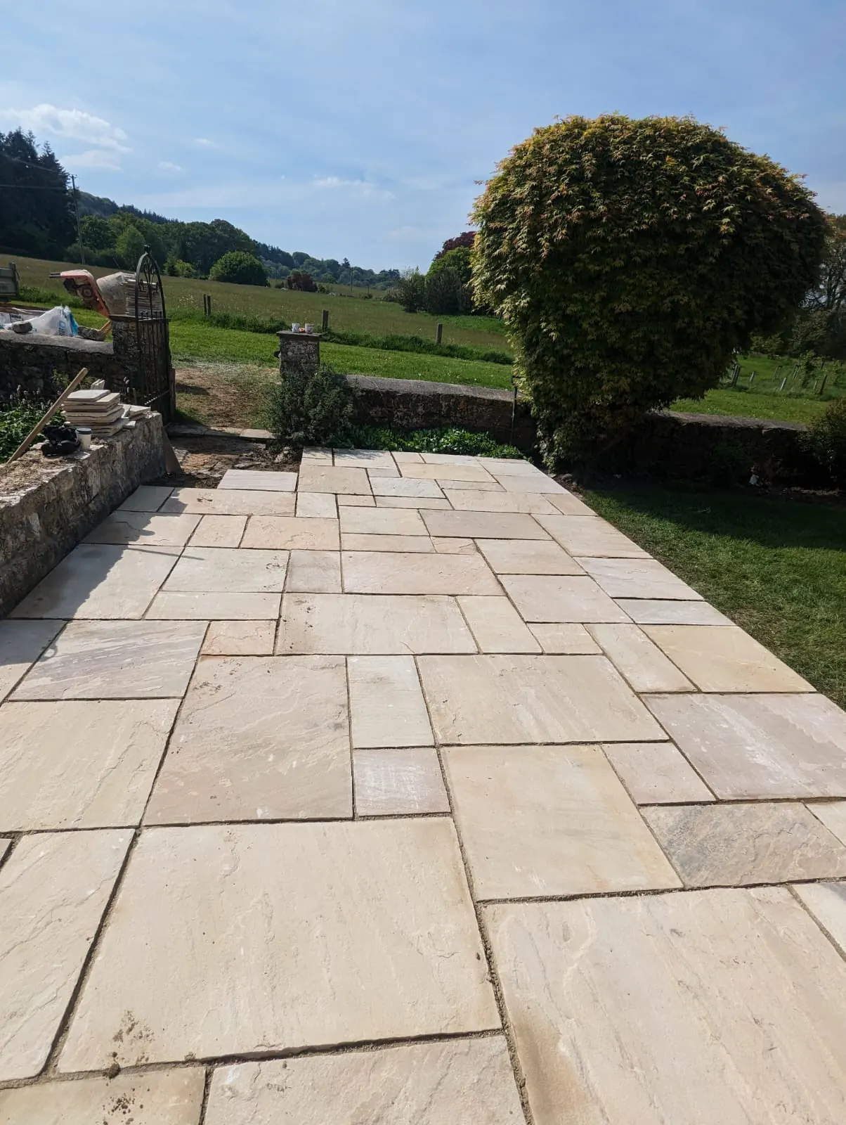 A sandstone patio overlooking a garden and open countryside