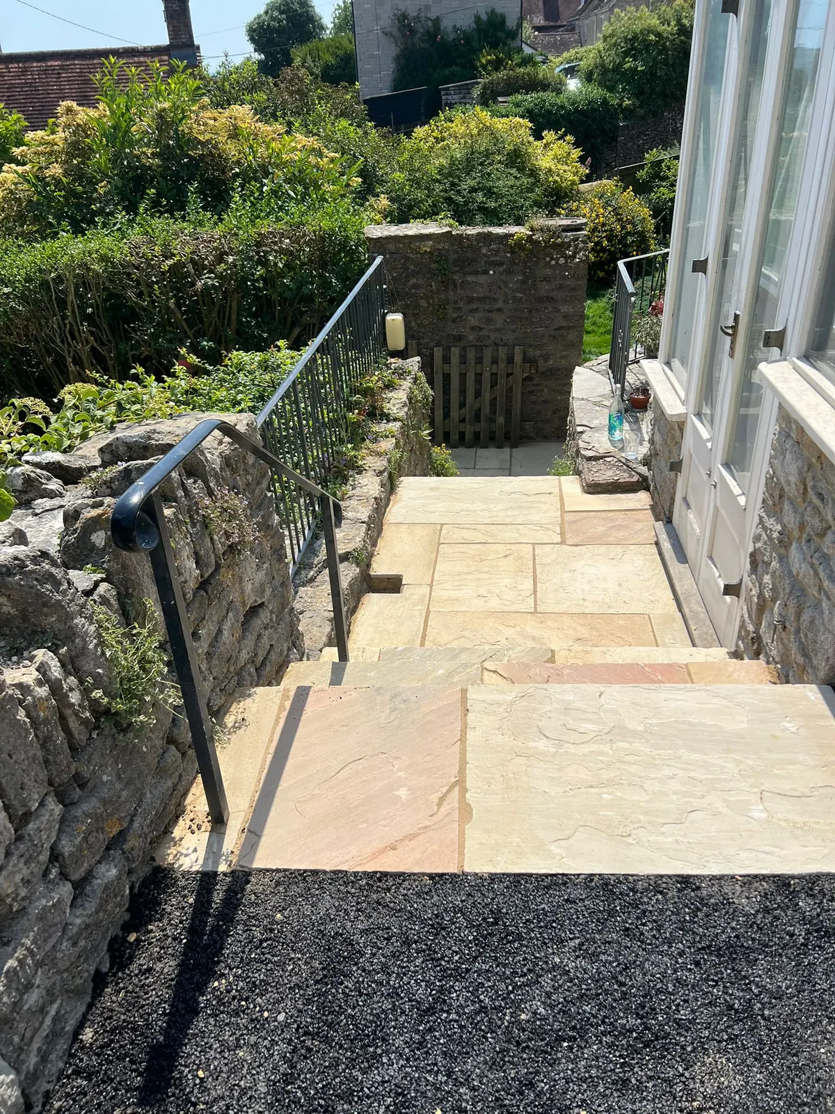Sandstone garden steps fitted with black iron railings