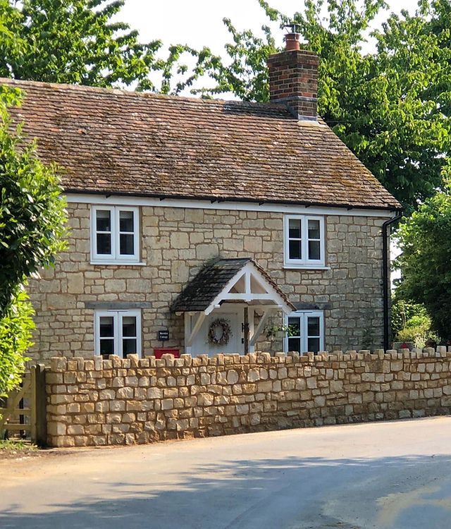 A stone cottage with a new dry stone boundary wall along the lane