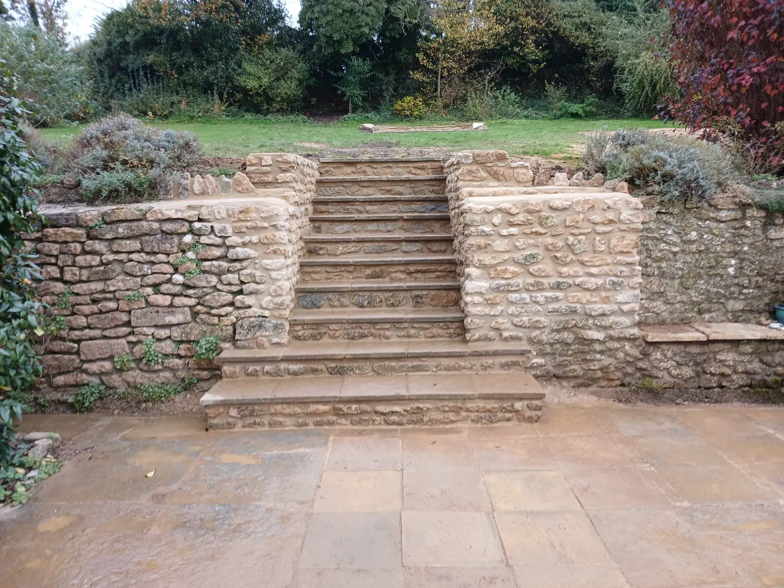 Stone garden steps between curved stone retaining walls