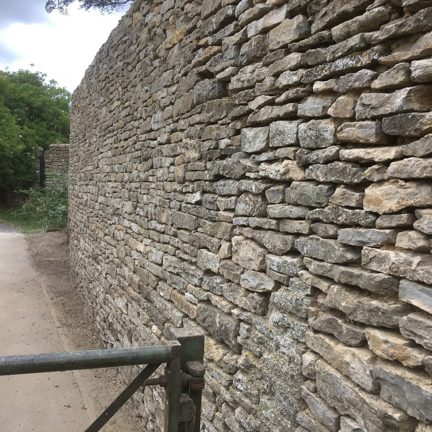 A long dry stone wall beside a narrow lane