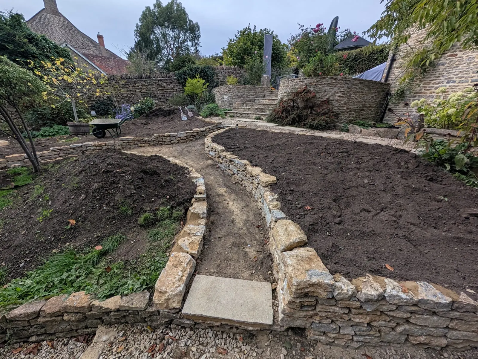 A winding garden path defined by low natural stone edging