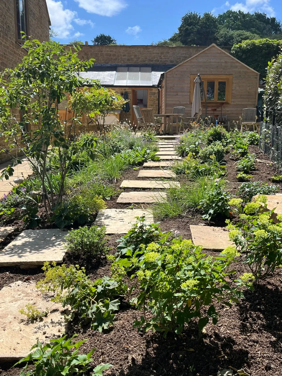A finished cottage garden with sandstone steps, paths and planted borders