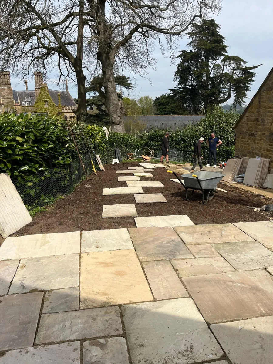 A new sandstone patio leading to a stepping-stone garden path