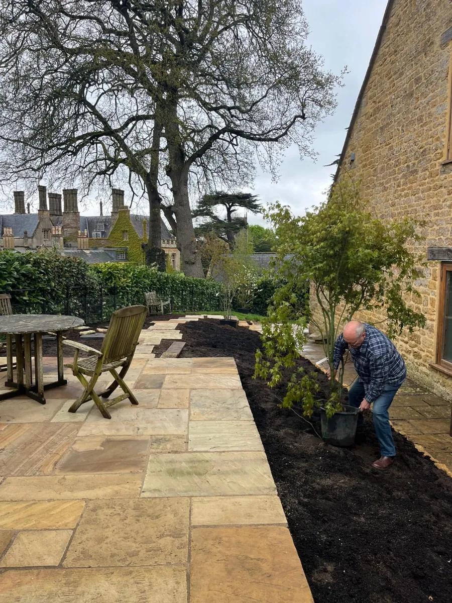 A sandstone path being laid beside a traditional stone house